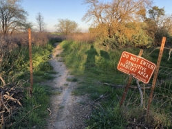 100 feet beyond the sign is a farm, so maybe it applies to just the buffer area? I think that's what the people I saw walking their dogs on the other side thought